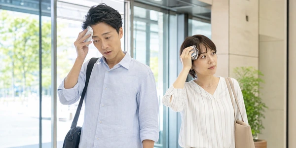 夏の屋外で頭皮と髪を気にする日本人男女